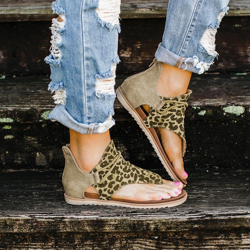 Damen-Sandalen mit Leopardenmuster, offener Zeh, beige, lässig, Sommermode, auf Holztreppe.