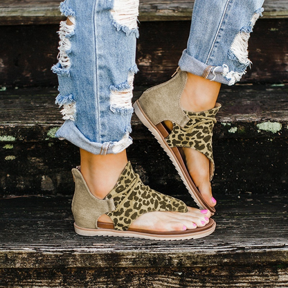 Damen-Sandalen mit Leopardenmuster, offener Zeh, beige, lässig, Sommermode, auf Holztreppe.