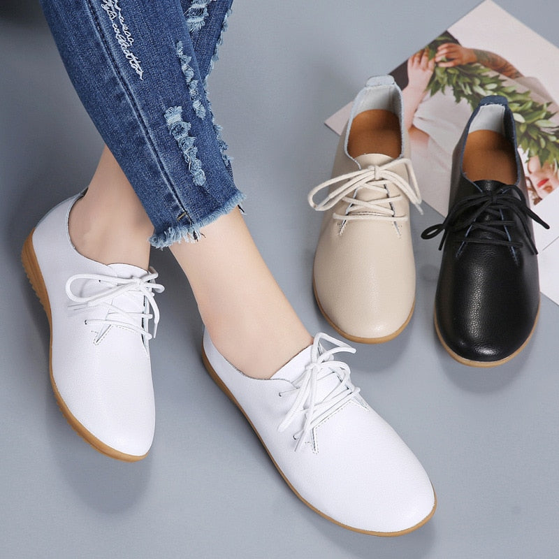 Damen-Lederschnürschuhe in Weiß, Beige und Schwarz, lässig, bequem, modisch, auf grauem Hintergrund.