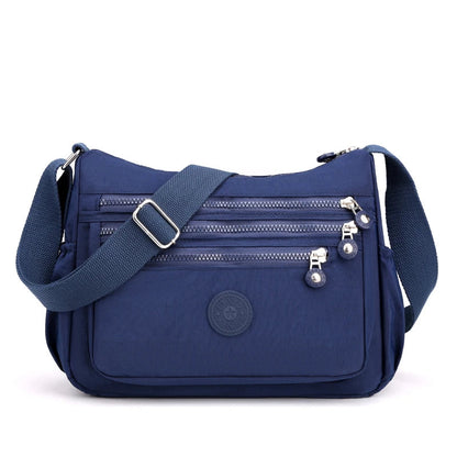 Blaue Umhängetasche mit Reißverschlüssen, verstellbarem Gurt, ideal für Damen, Freizeit, Reisen.