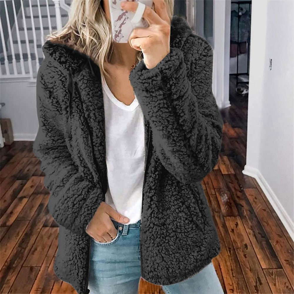 Frau in schwarzer Teddyfelljacke, weißem T-Shirt und Jeans, modisch, gemütlich, Herbstmode.