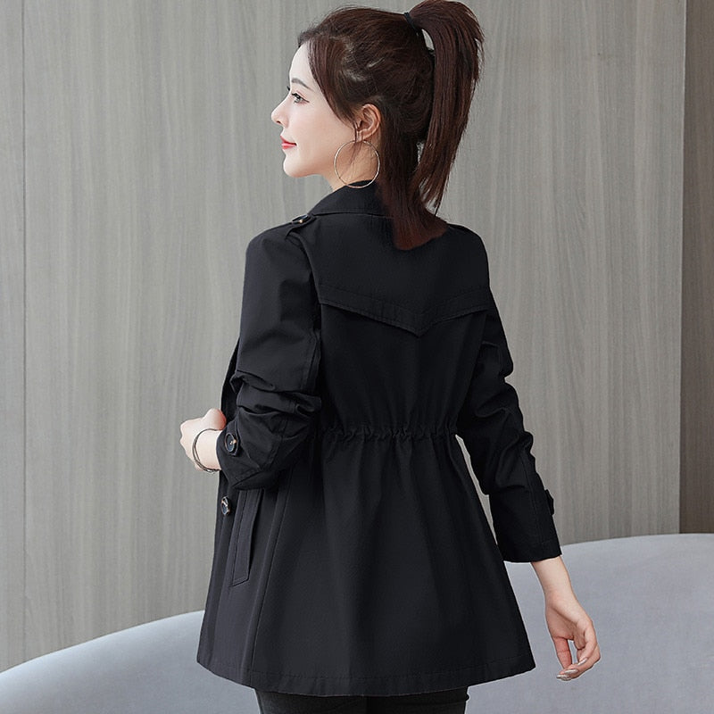 Frau in schwarzer Damenjacke, elegant, langärmelig, mit Taillenzug, modisch, Rückansicht.