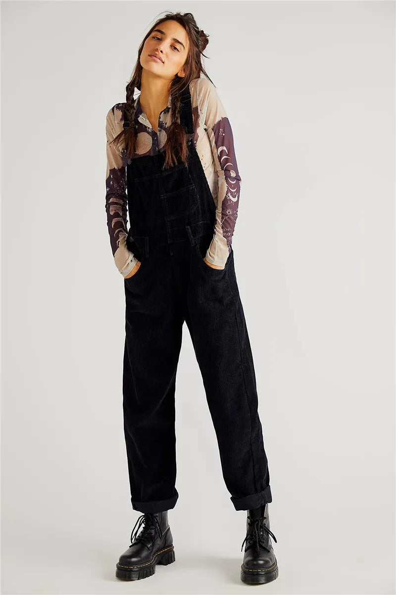 Frau in schwarzem Cord-Overall und Stiefeln, lässige Mode, Herbst-Outfit, Streetwear-Look.