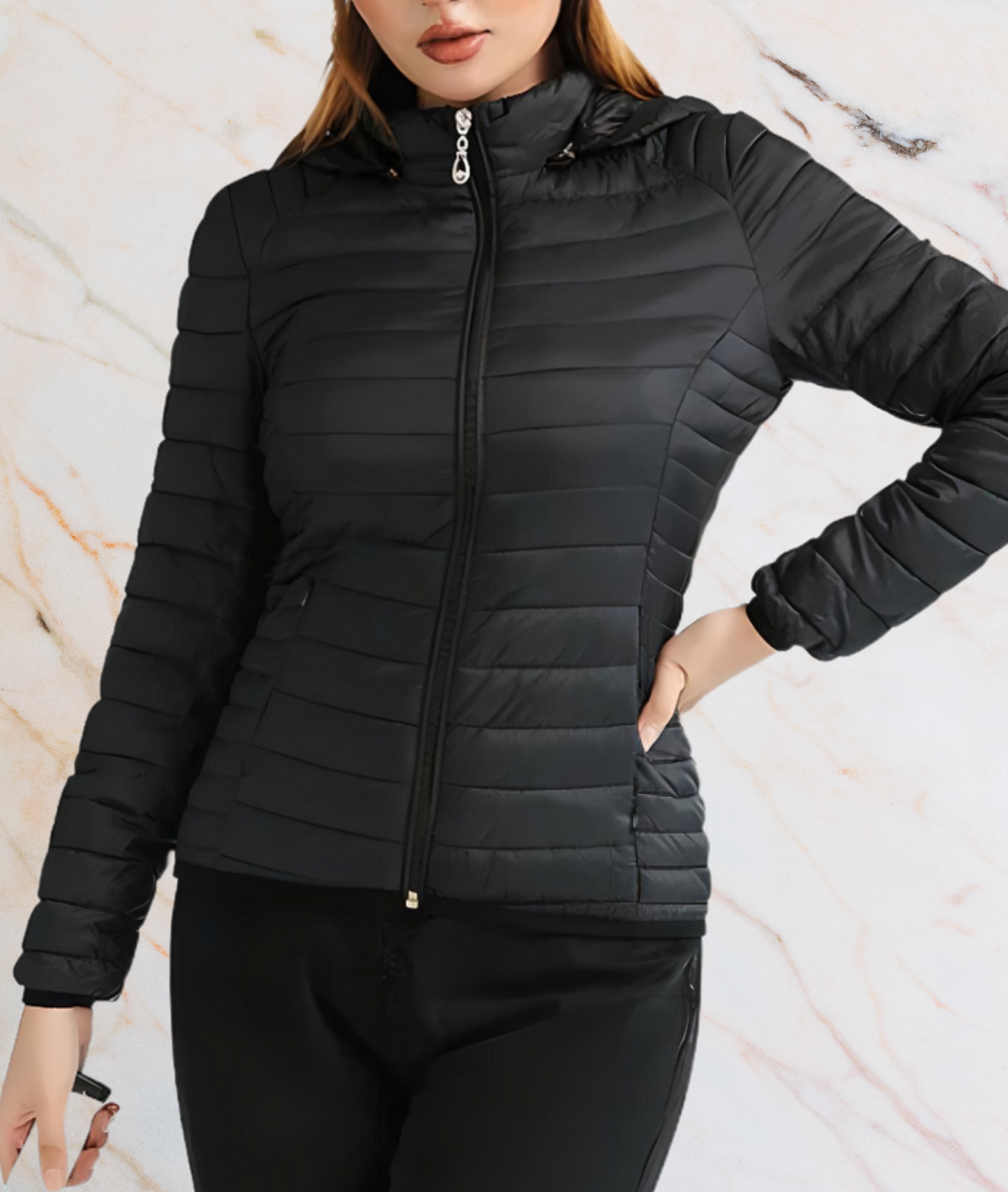 Frau in schwarzer Steppjacke mit Kapuze vor Marmorhintergrund.