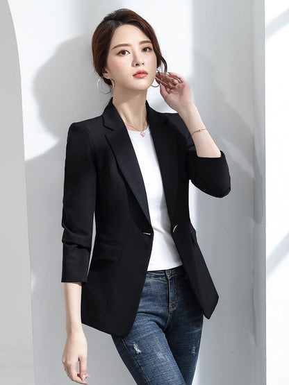 Frau in schwarzem Blazer, weißem T-Shirt und Jeans, Business-Casual-Look, Modefotografie.