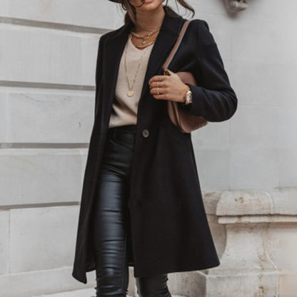 Frau in schwarzem Wollmantel, Lederhose, beige Pullover, braune Tasche, modisch, elegant.