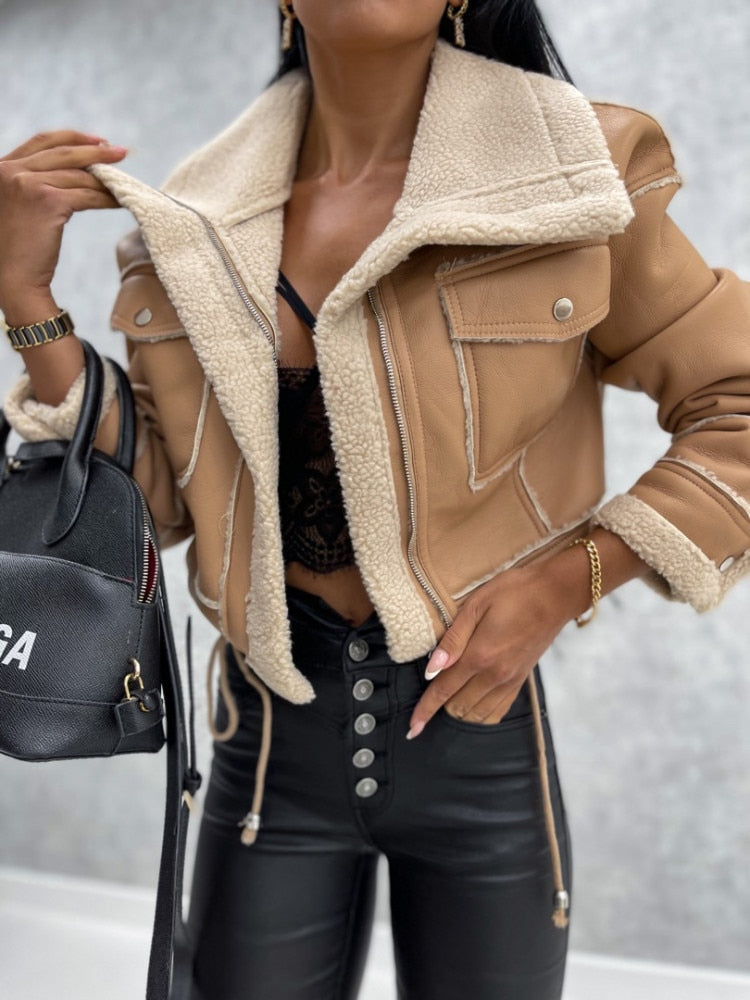 Frau in brauner Lammfelljacke, schwarze Lederhose, modisch, Herbstmode, Damenbekleidung.