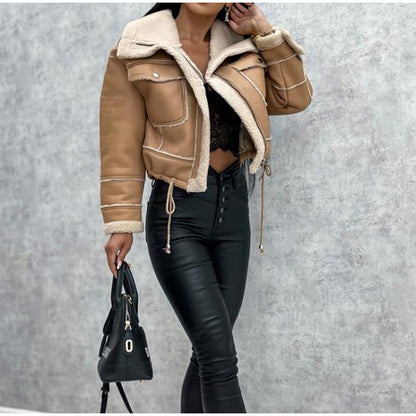 Frau in brauner Lederjacke mit Sherpa-Futter, schwarze Hose, Handtasche, modisch, Herbstmode.