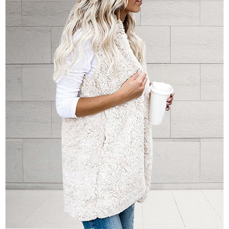 Frau in weißer Teddyfell-Weste mit Kaffeebecher, lässige Mode, Herbst-Winter-Outfit.