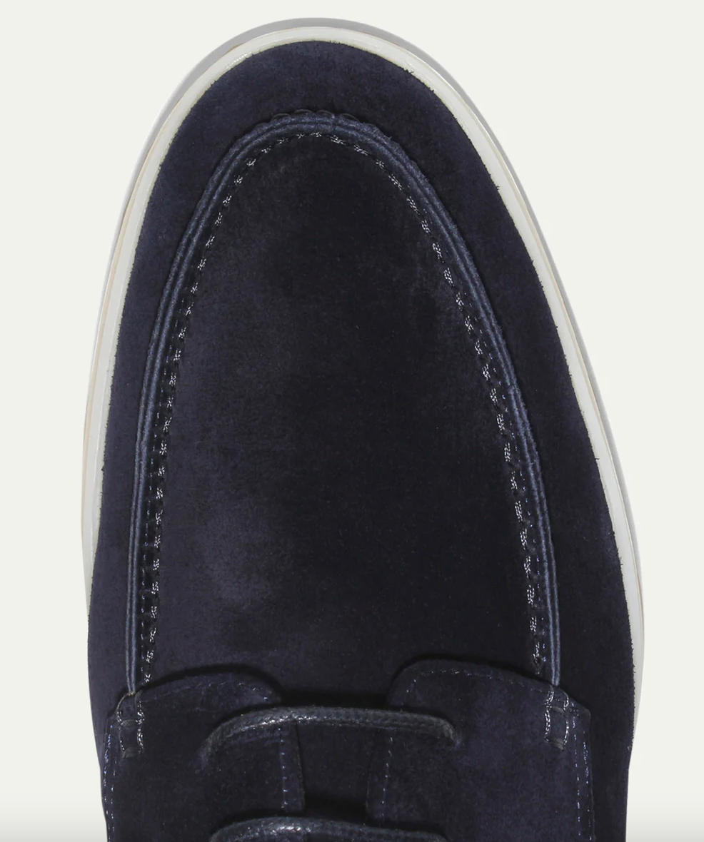 Dunkelblauer Wildlederschuh, Mokassin-Stil, weiße Sohle, Herrenmode, elegante Freizeitkleidung.