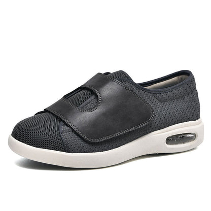 Dunkelgrauer orthopädischer Schuh mit Klettverschluss, atmungsaktivem Mesh und Luftpolstersohle.