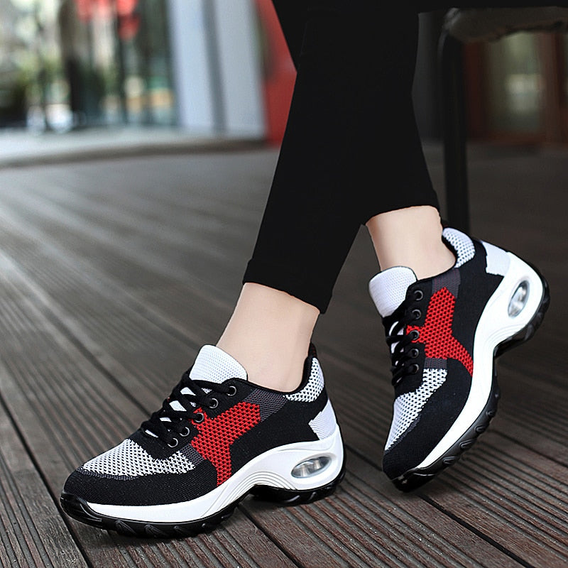 Schwarze und weiße Sportschuhe mit rotem Akzent, atmungsaktiv, ideal für Damenlauftraining.