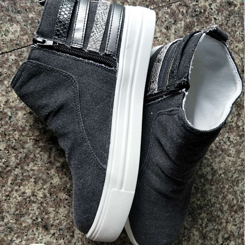 Dunkelgraue Damen-Sneaker mit Reißverschluss, weißer Sohle und Glitzerstreifen.