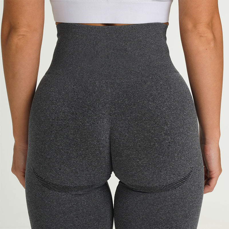 Frau in grauer, nahtloser Sportleggings, Rückansicht, hohe Taille, Fitnessmode.