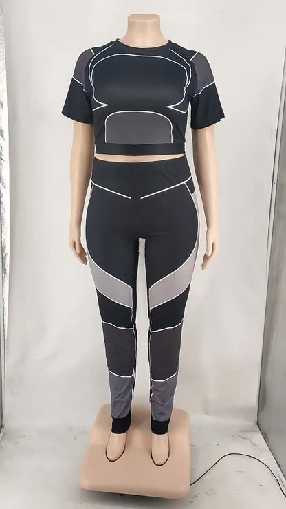 Schwarzes und graues Sport-Set für Damen, bestehend aus Crop-Top und Leggings.