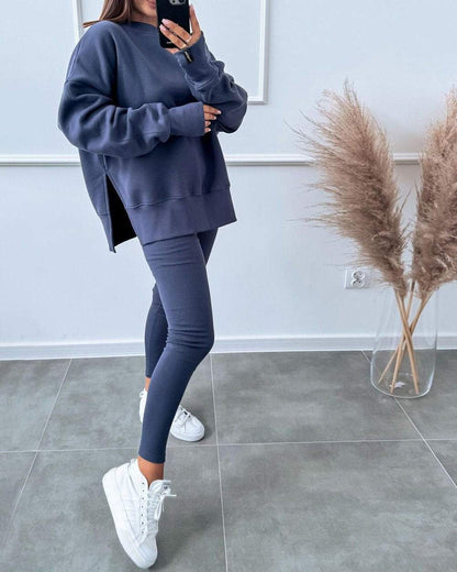 Frau in dunkelblauem Trainingsanzug mit weißen Sneakers, moderne Sportmode, Innenraum.