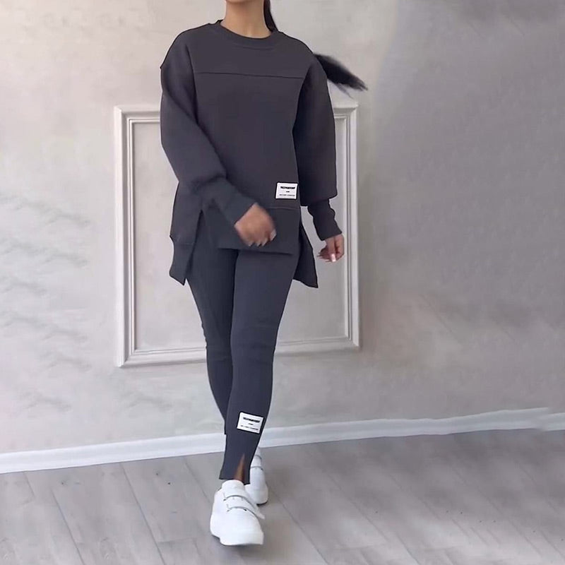 Frau in grauem Oversize-Sweatshirt und Leggings, weiße Sneaker, modisch, bequem, Freizeitkleidung.