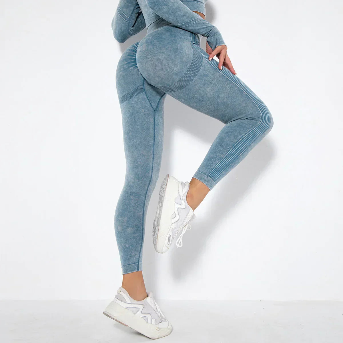 Frau in blauer nahtloser Sportleggings und Sneakers, Fitnessmode, Ganzkörperansicht.