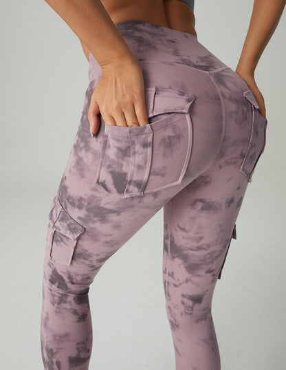 Frau in lila Batik-Leggings mit Taschen, sportlich, modisch, bequem, Freizeitkleidung.
