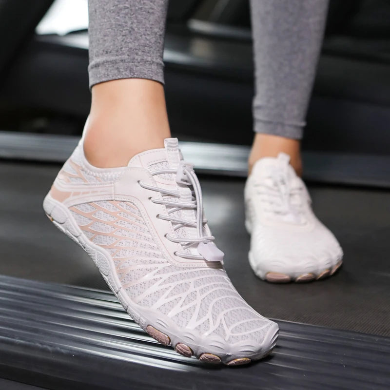 Weiße Damen-Laufschuhe mit Netzdesign auf Laufband, ideal für Fitness und Sport.