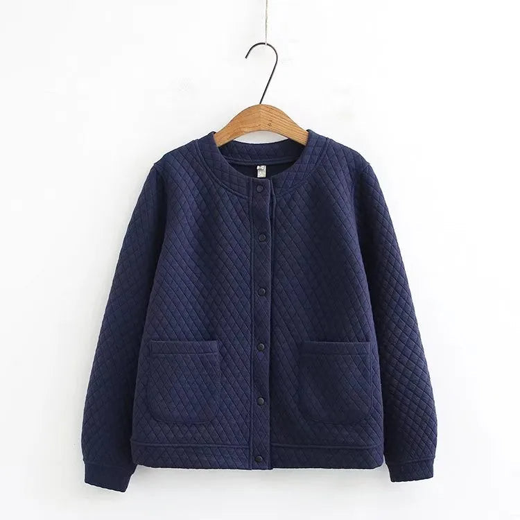 Dunkelblaue gesteppte Jacke aus Baumwolle, Knopfleiste, zwei Taschen, auf Holzkleiderbügel.