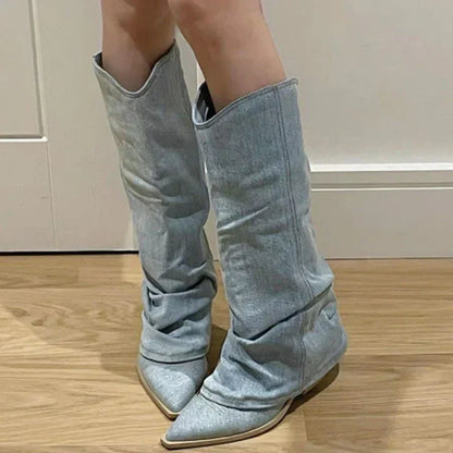 Graue Damenstiefel aus Denim, spitz zulaufend, knielang, modisch, auf Holzboden.