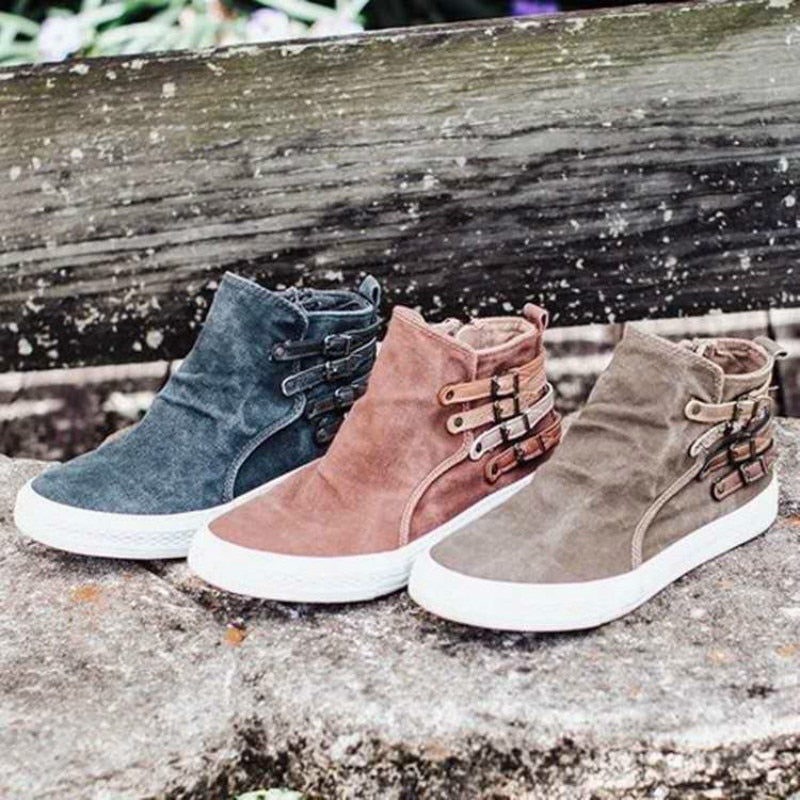 Drei Paar Wildleder-Sneaker in Blau, Braun und Beige mit Schnallen auf Steinbank.