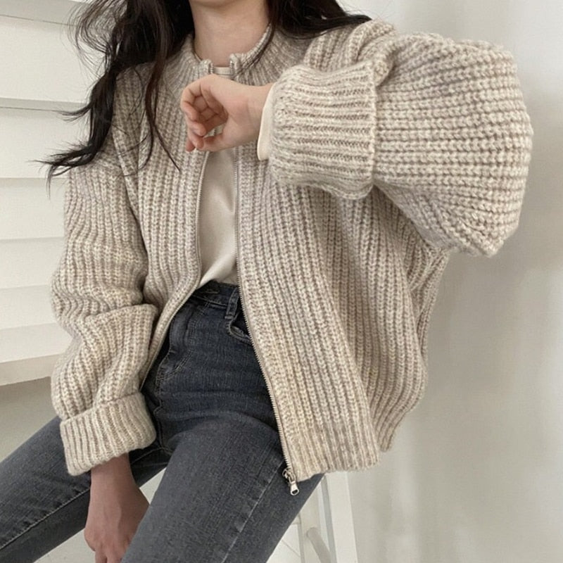 Frau trägt beige Strickjacke, Reißverschluss, lässig, modisch, Herbstmode, Damenbekleidung.