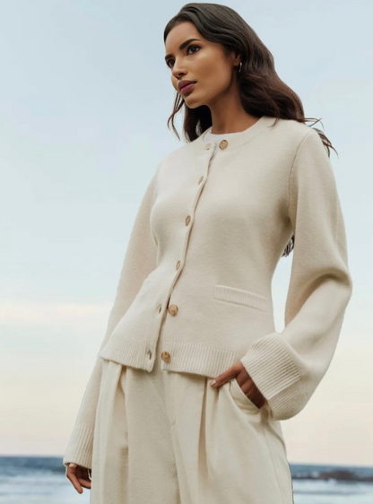 Frau in cremefarbenem Strick-Cardigan am Strand, elegantes Herbst-Outfit, Damenmode.