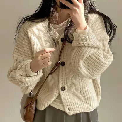 Frau in cremefarbener Strickjacke mit Knöpfen, braune Umhängetasche, lässiger Stil.