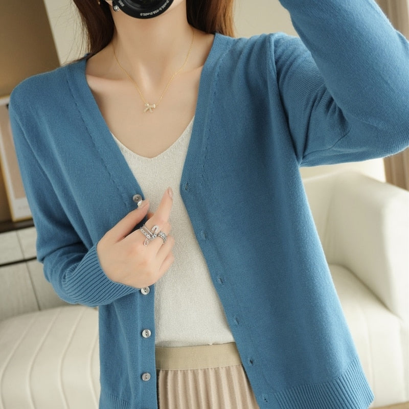 Frau trägt blauen Strick-Cardigan, V-Ausschnitt, Knöpfe, elegantes Design, Damenmode.