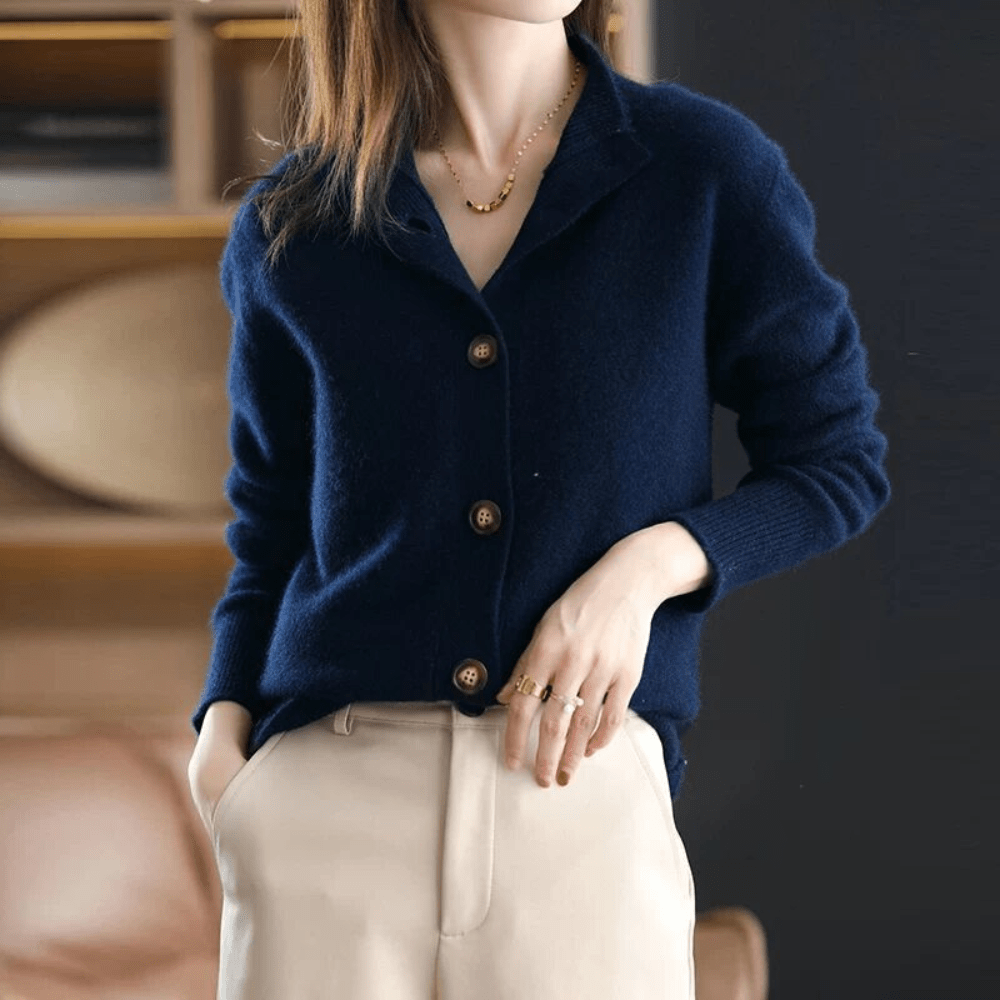 Dunkelblauer Damen-Cardigan aus Wolle mit Knöpfen, kombiniert mit beigen Hosen.