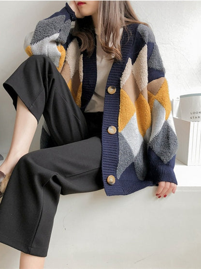 Frau trägt bunte Strickjacke mit Rautenmuster, schwarze Hose, lässiger Herbstlook.