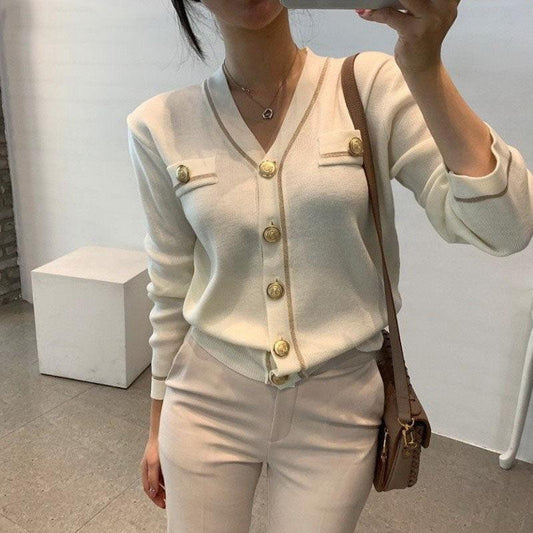 Frau in cremefarbenem Cardigan mit goldenen Knöpfen, elegantes Outfit, modisch, stilvoll.