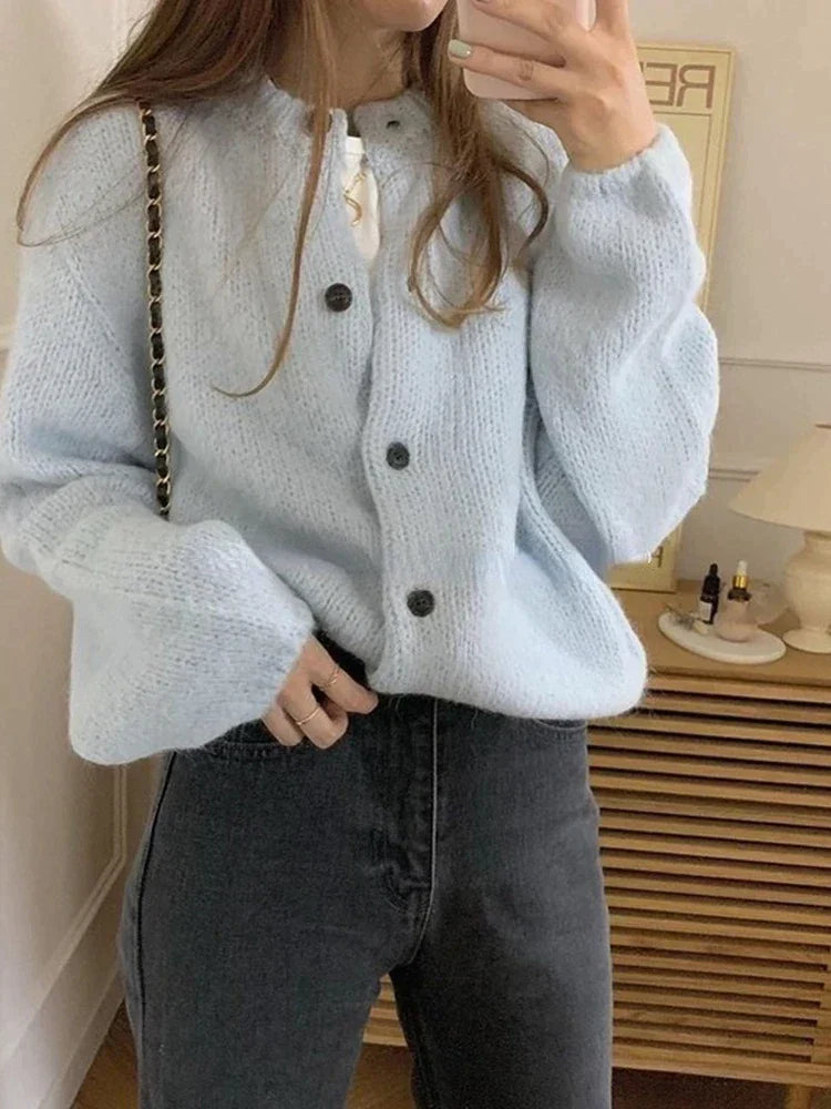Frau in hellblauer Strickjacke mit Knöpfen, Oversize, Herbstmode, gemütlich, modisch.