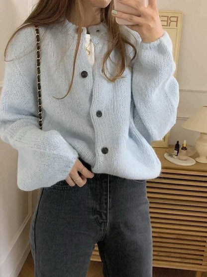 Frau in hellblauer Strickjacke mit Knöpfen, Oversize, Herbstmode, gemütlich, modisch.