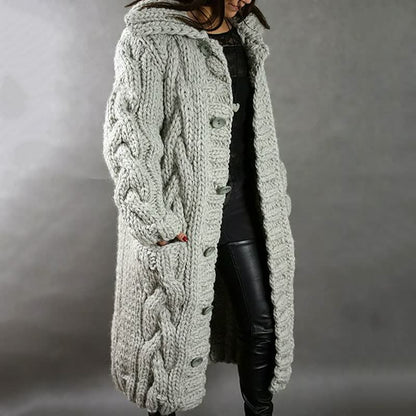 Frau in grauem, grob gestricktem Wollmantel mit Zopfmuster, modisch, warm, Winterkleidung.