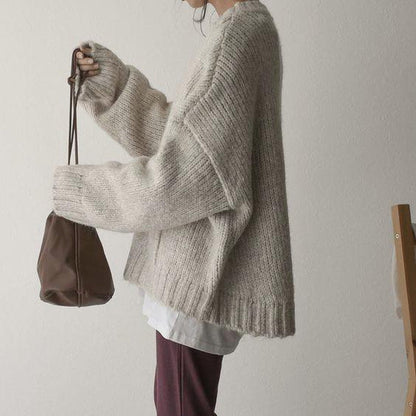 Frau in beigem Strickpullover mit brauner Tasche, lässiger Herbstlook, gemütliche Mode.