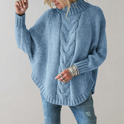 Frau in hellblauem Strickpullover mit Zopfmuster und Jeans, modisch, gemütlich.