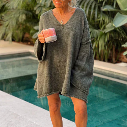 Frau in grauem Strickpullover mit Tasse am Pool, lässige Mode, Outdoor, gemütlich.