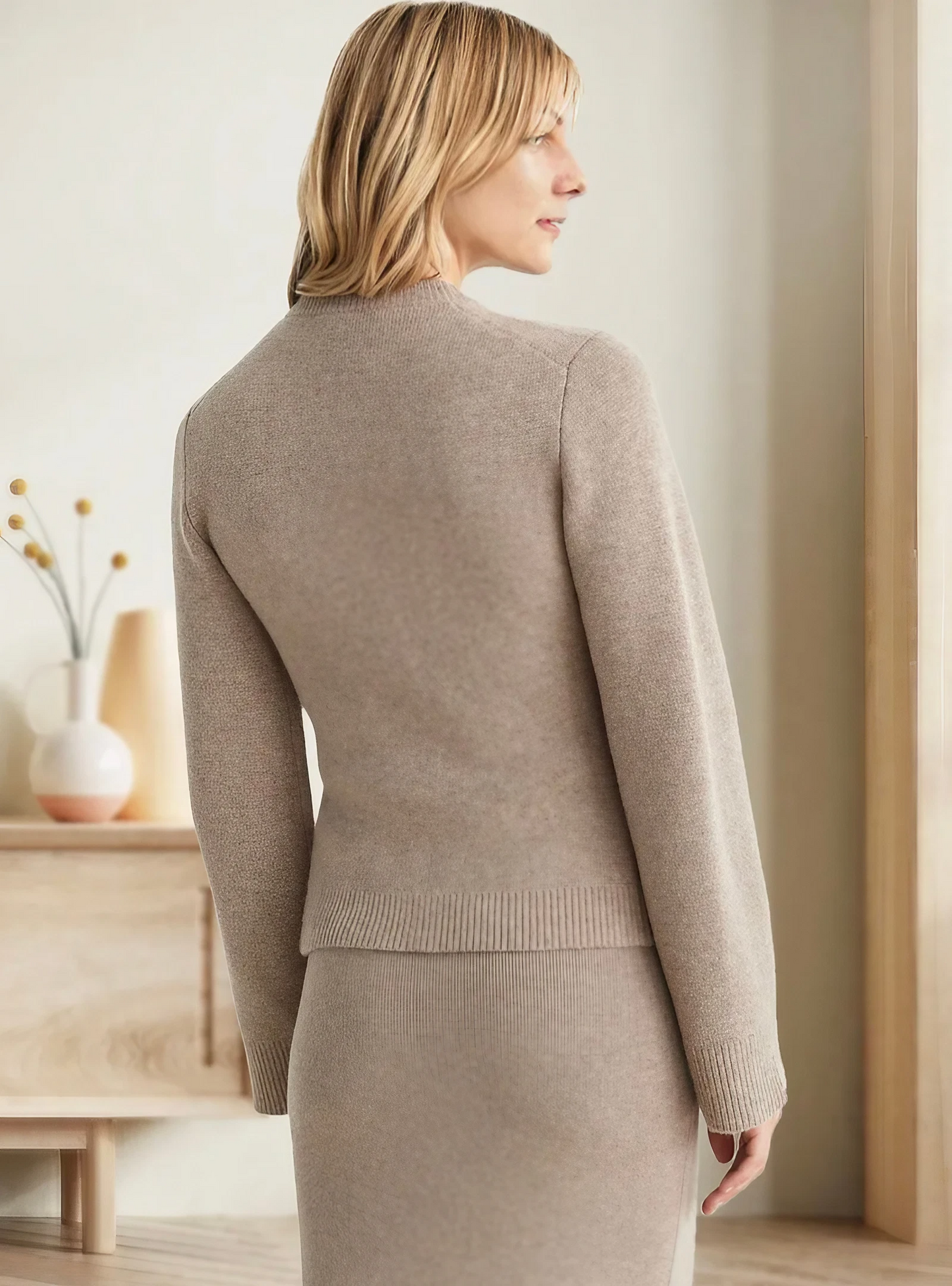 Frau in beigem Strickpullover und Rock, elegantes Outfit, moderne Mode, Innenraum.