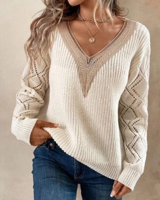 Frau trägt cremefarbenen Strickpullover mit V-Ausschnitt und Spitzenmuster, lässige Mode.