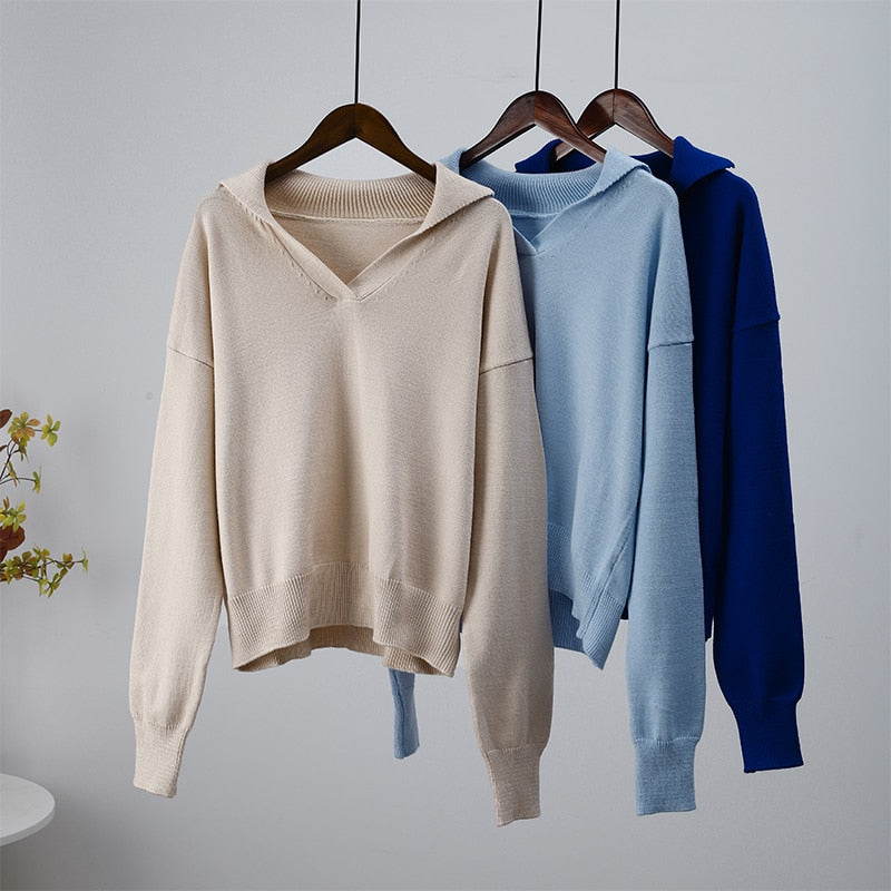 Drei Pullover mit Kapuze, beige, blau, dunkelblau, Baumwolle, Damenmode, auf Kleiderbügeln.
