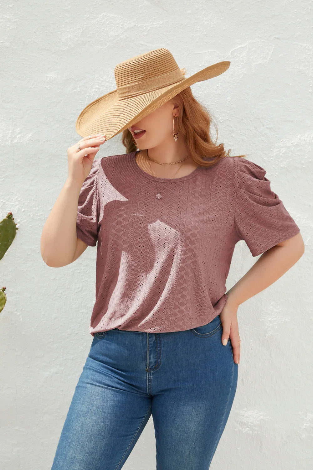Frau mit Strohhut, lila T-Shirt, blaue Jeans, lässiger Sommerlook, Modefotografie.