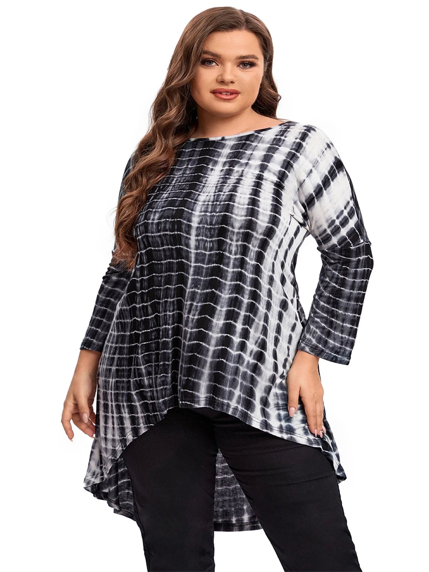 Frau in schwarz-weißem Batik-Longshirt, lange Ärmel, asymmetrischer Saum, Plus-Size-Mode.