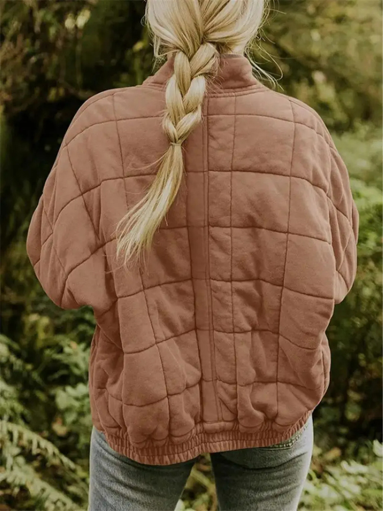 Frau in rosa gesteppter Übergangsjacke, oversized, im Freien, Herbstmode, Damenbekleidung.