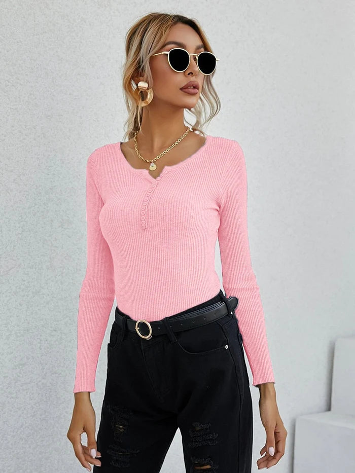 Frau in rosa V-Ausschnitt Pullover, schwarze Hose, Sonnenbrille, modisch, elegant, Damenmode.