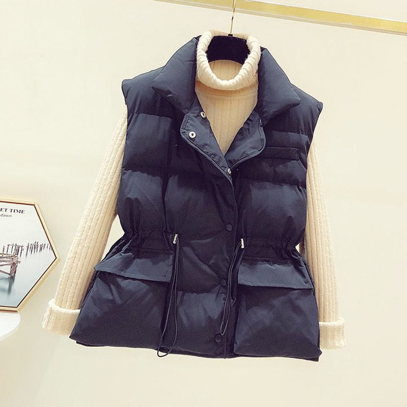Schwarze Daunenweste mit beigem Rollkragenpullover, modische Winterbekleidung für Damen.