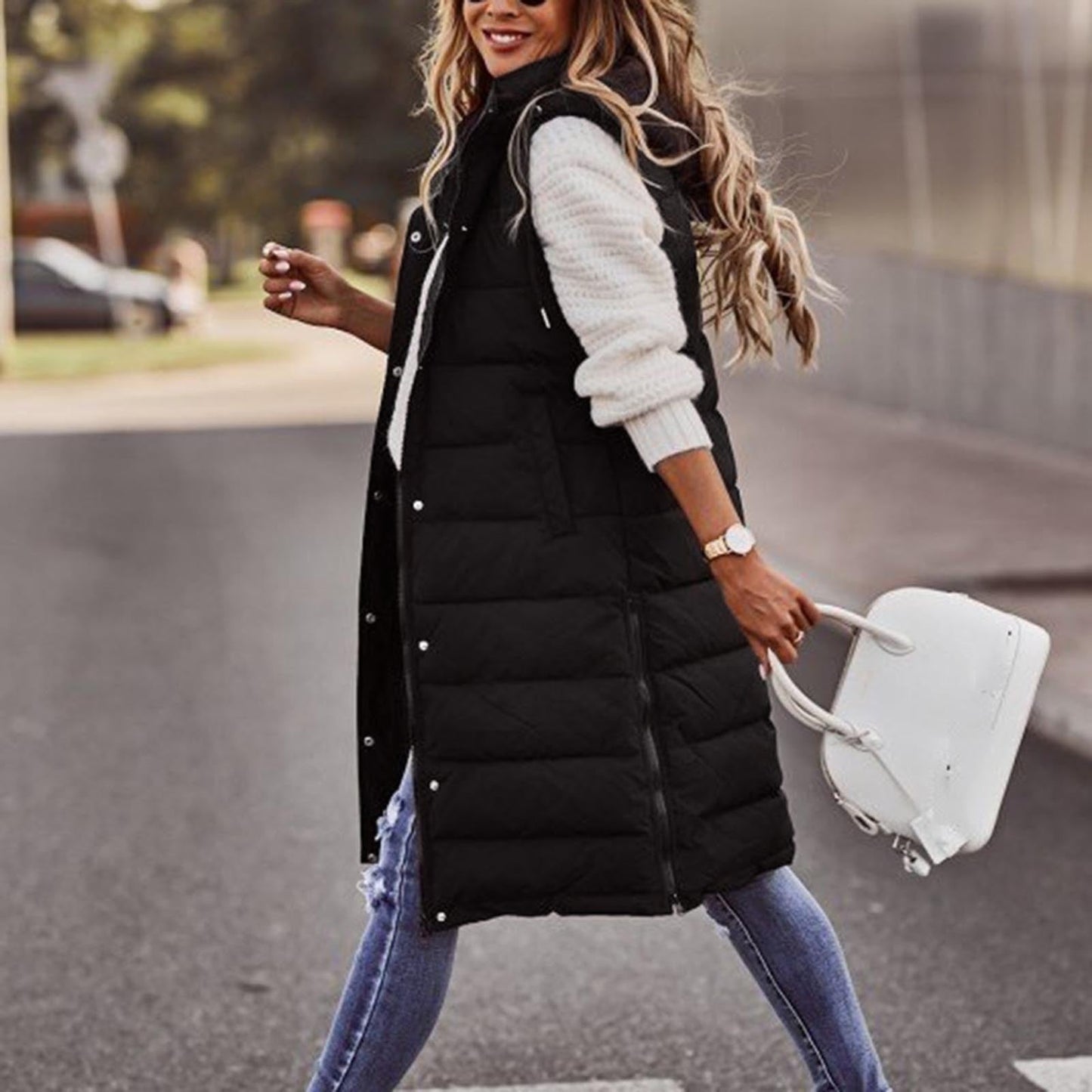 Frau in schwarzer Steppweste, weiße Handtasche, lässiger Herbstlook, Straße, Mode.
