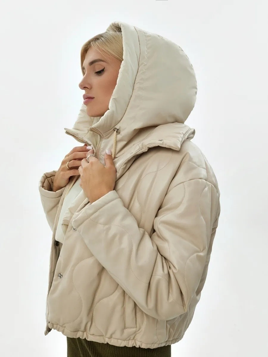 Frau in beiger Steppjacke mit Kapuze, Wintermode, warm, stilvoll, Damenbekleidung.
